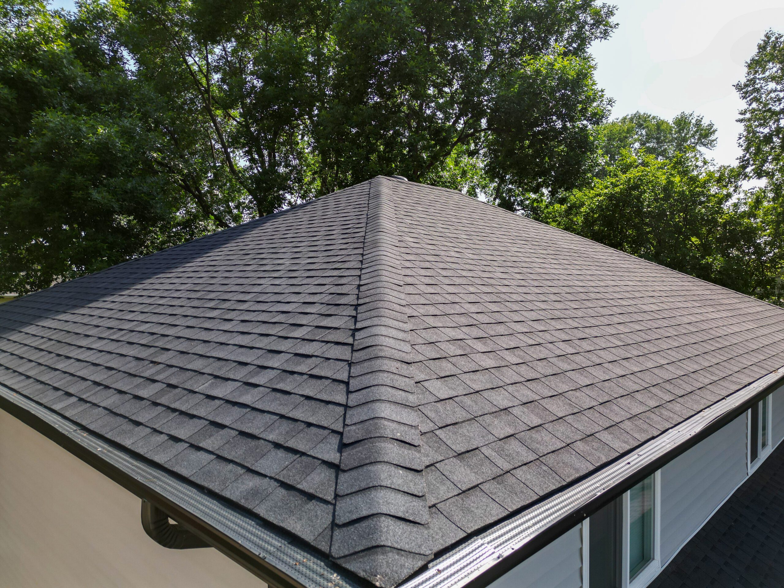Close-up view of the new shingles at the roof peak installed by Wolf Roofing