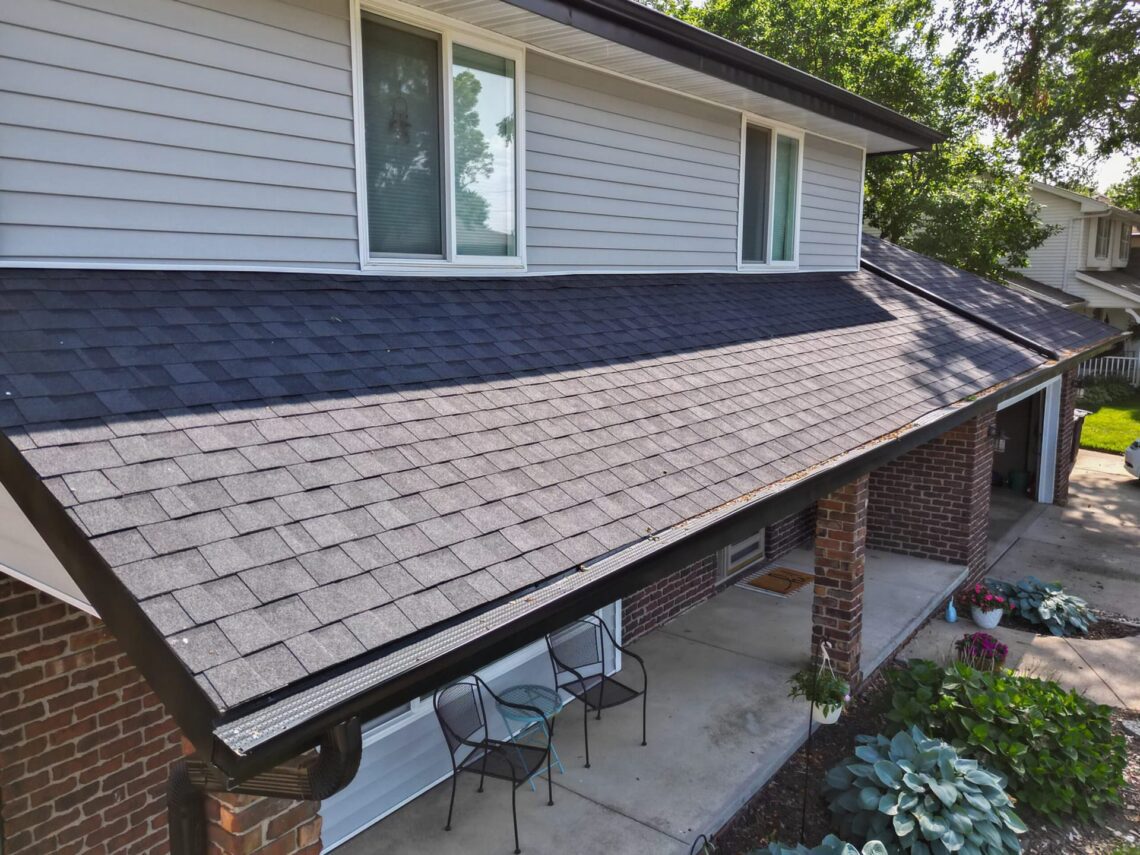 Close-up view of the front porch roof with detailed shingle work and guttering.