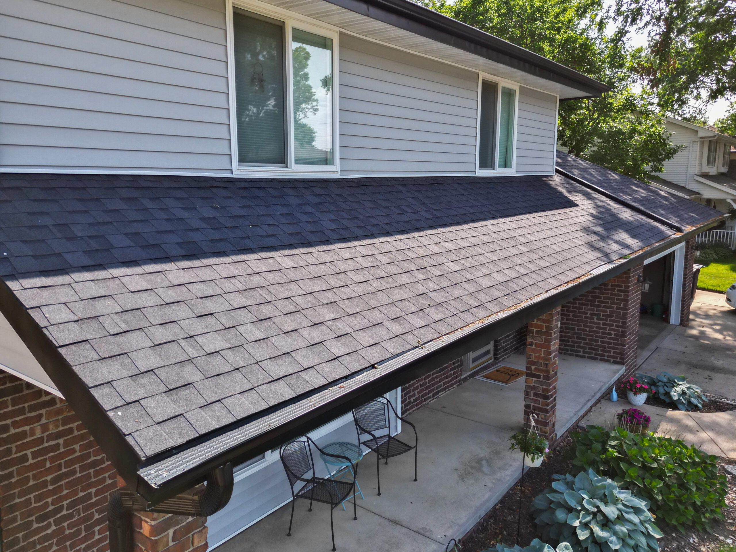 Close-up view of the front porch roof with detailed shingle work and guttering.