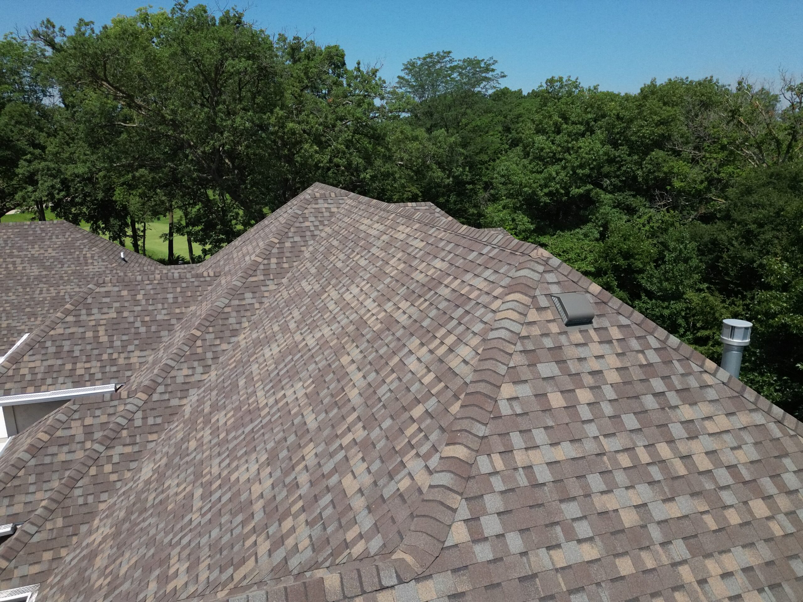 Close-up aerial of asphalt shingles on a complex re-roofing project in Polk City by Wolf Roofing.