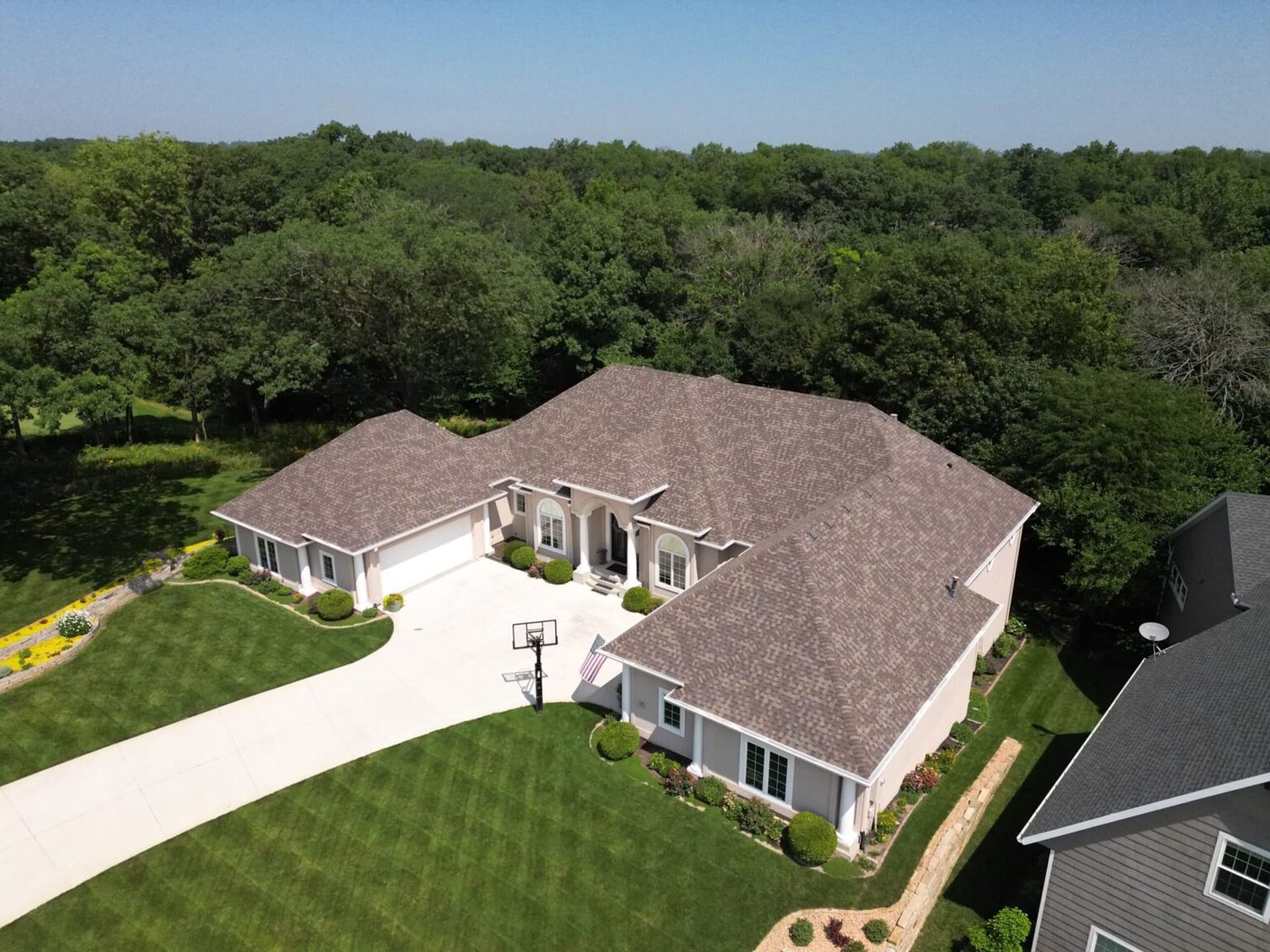 polk-city-iowa-home-roofing-aerial-front-angle-wolf-roofing-scaled-min Aerial front angle of complete residential roof replacement in Polk City by Wolf Roofing.