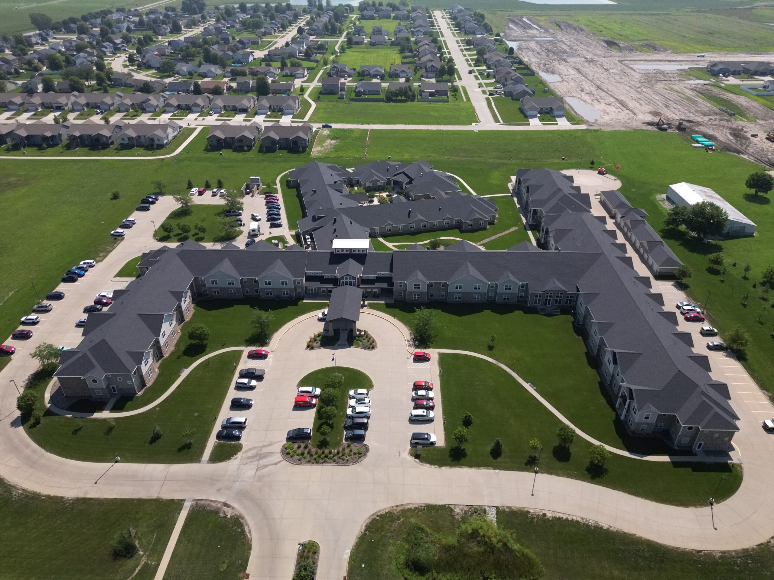 A wide aerial view of Prairie Vista Apartments showing the full layout and new roof installation