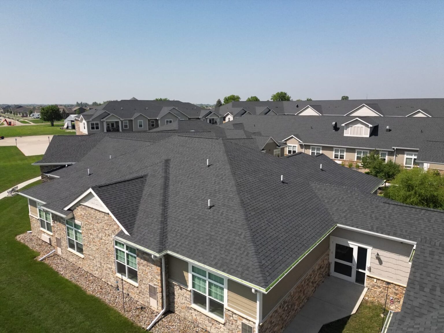 prairie-vista-village-roof-rear-close-detail-view-wolf-roofing-scaled-min Close view of rear wing roof sections and intersecting slopes