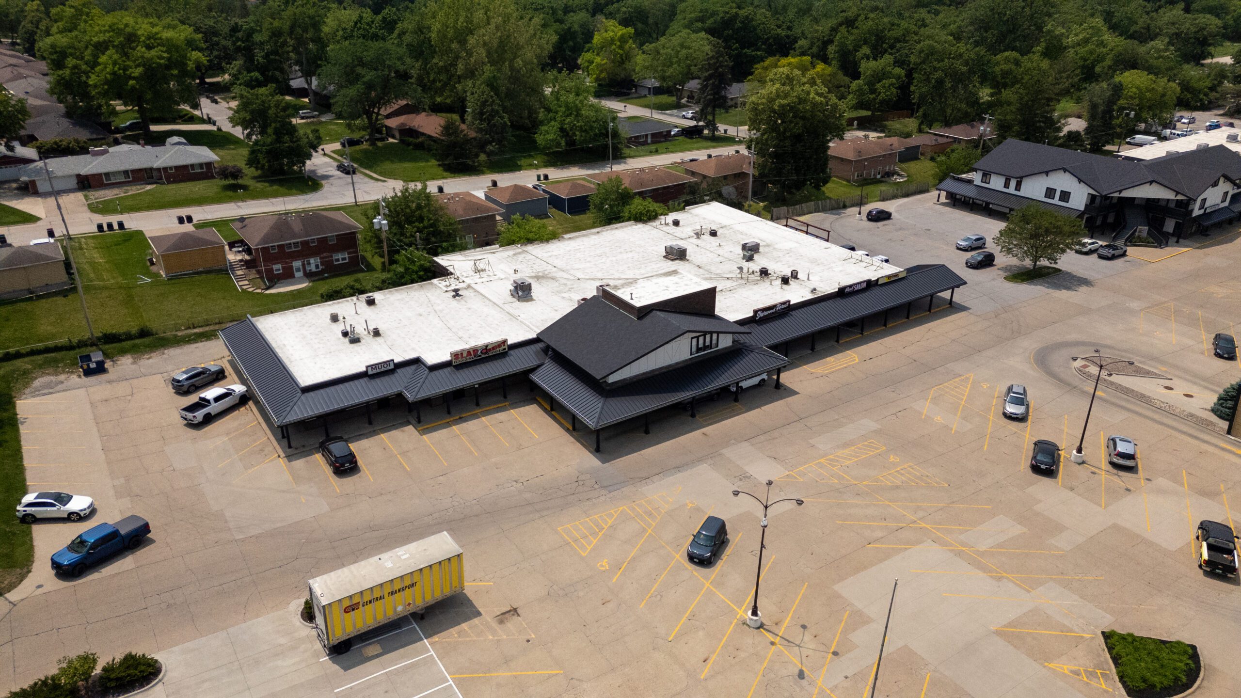 Aerial view of Sherwood Forest shopping center showing newly installed shingled roof section