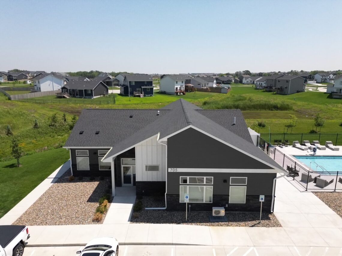 Straight-on view of the Pitch Apartments building with completed asphalt shingle roofing