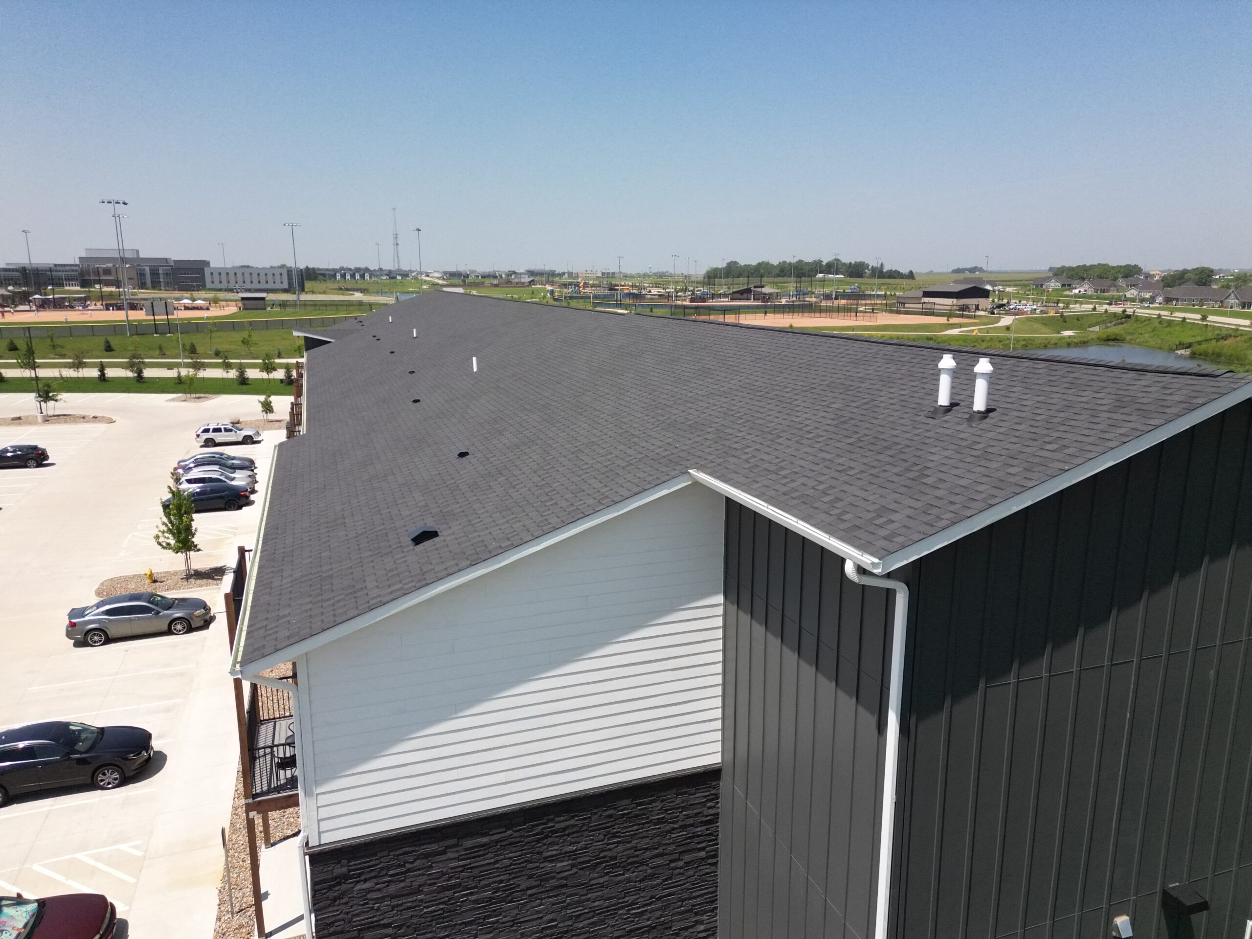 Right side angle showing shingle roofing across The Pitch Apartments