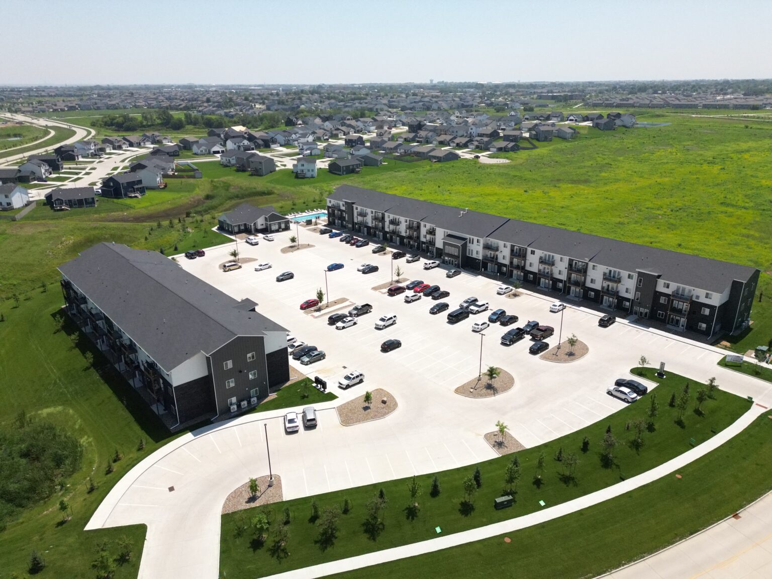 Wide aerial view of The Pitch Apartments showcasing full roof installation by Wolf Roofing