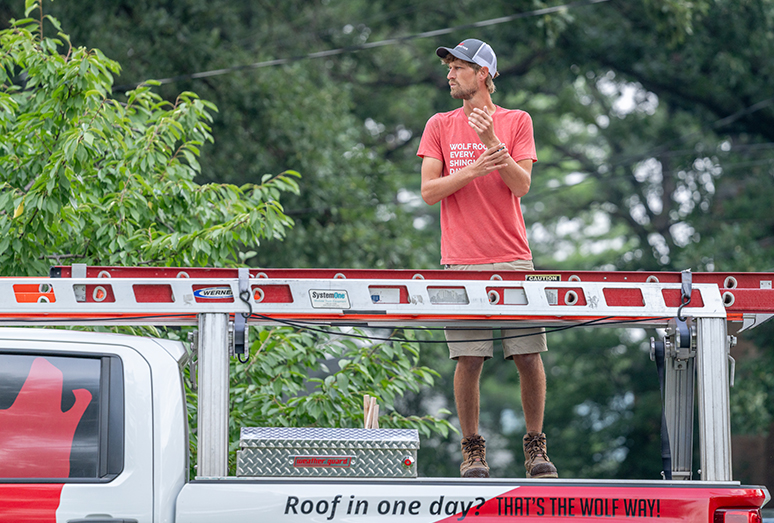Worker for Wolf Roofing Inspecting a Roof
