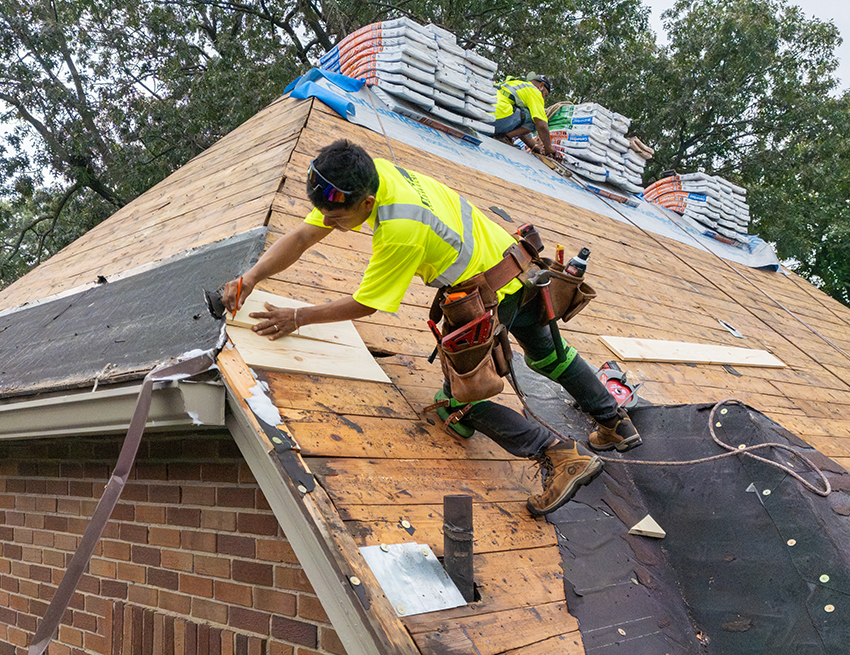 Workers replacing a roof in Central Iowa for Wolf Roofing