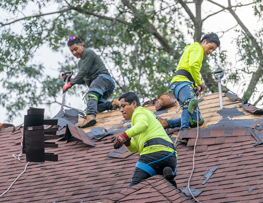 Workers replacing a roof in Central Iowa for Wolf Roofing