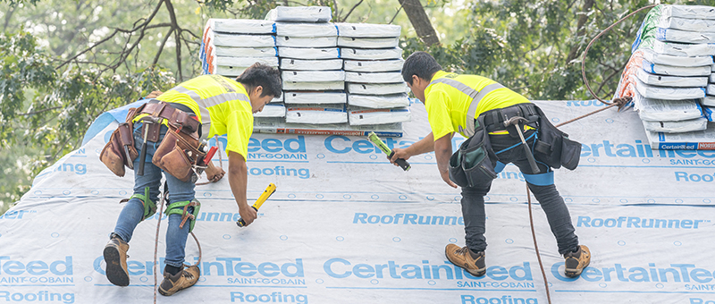 Workers replacing a roof in Central Iowa for Wolf Roofing