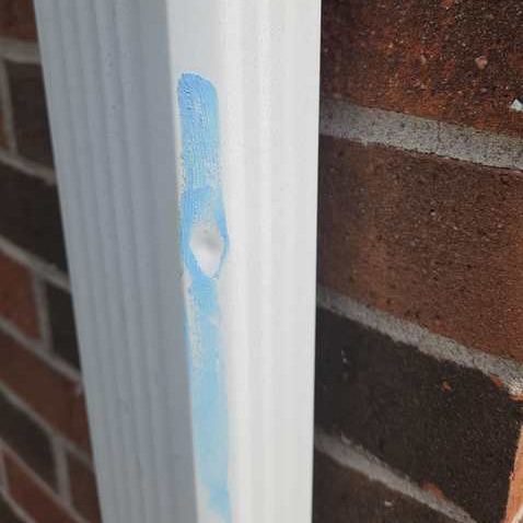 hail-damage-marking Wolf Roofing marking hail damage on a downspout