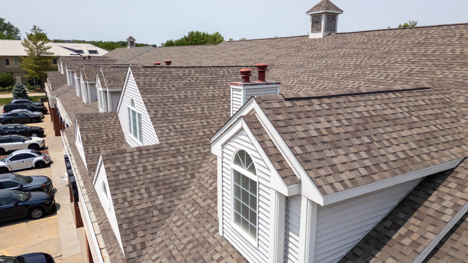 Steep-slope asphalt shingle roof with dormers on a multifamily building