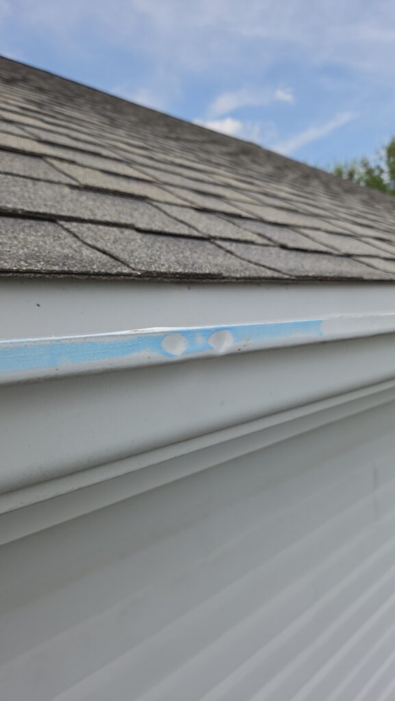 Hail hits marked on a gutter during a HAAG-certified inspection for insurance claims assistance