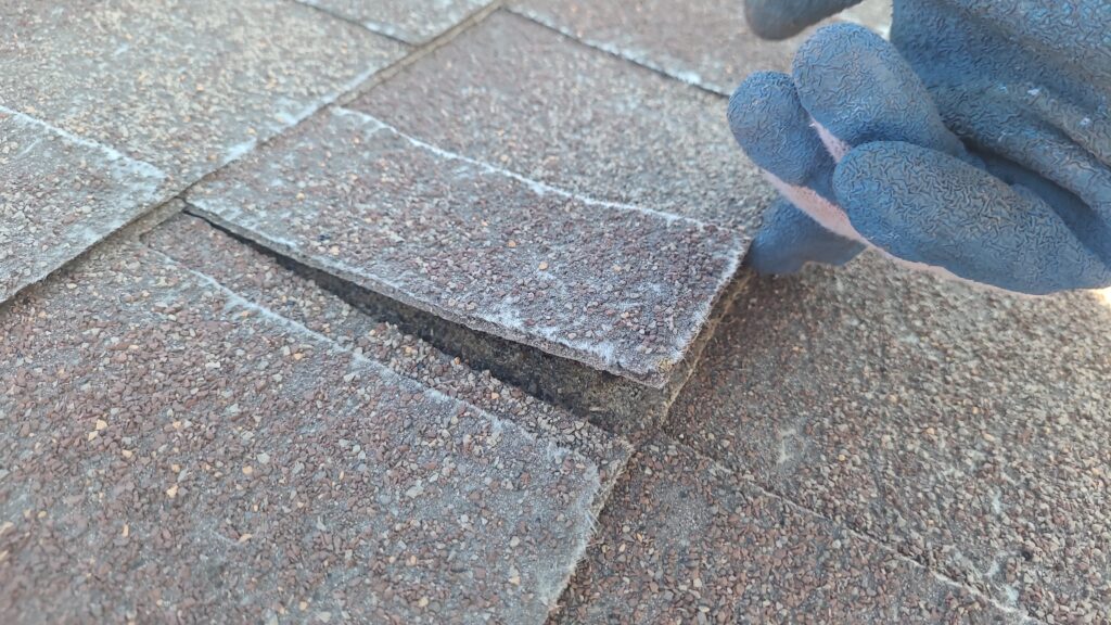Lifted Shingle Wind Damage Before Lifted shingle showing wind damage before replacement in Johnston, IA