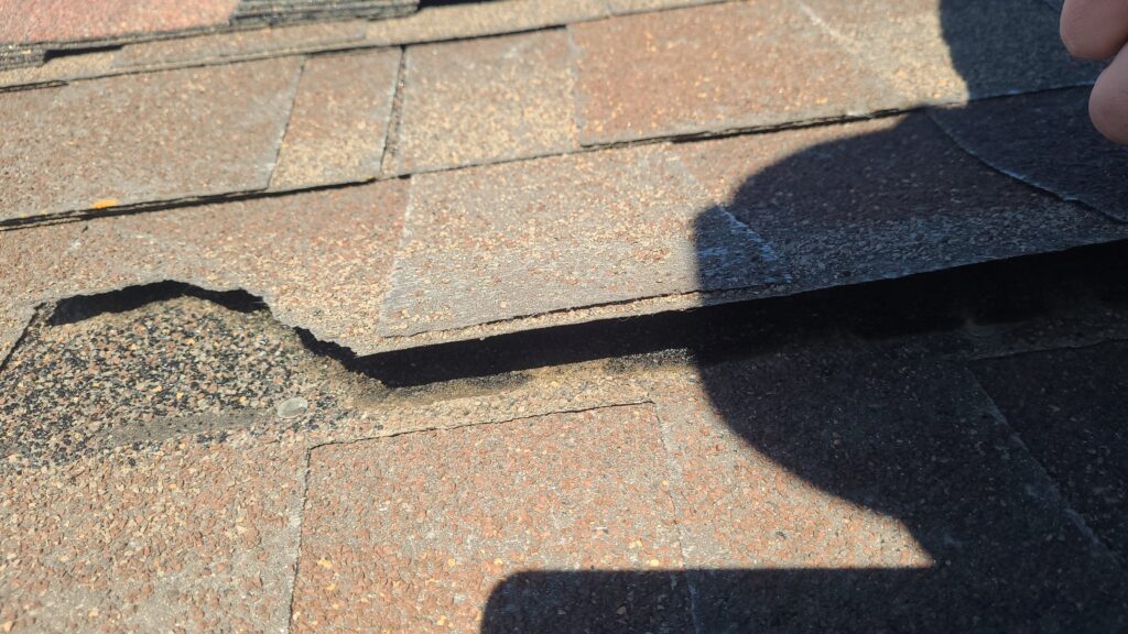 Storm Damaged Shingles Before Storm-damaged shingles on a Johnston, IA home before roof replacement