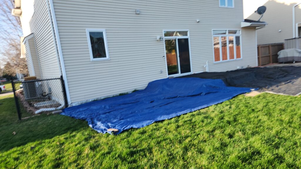 Tarps protecting landscaping during an Ankeny roof replacement