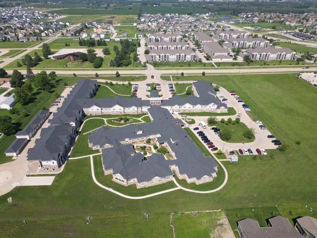Aerial view of a townhome and multifamily community with asphalt shingle roofs