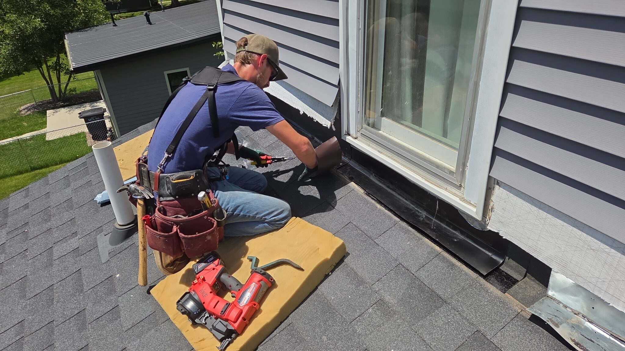 Wolf Roofing roofer repairing flashing where the roof meets the wall
