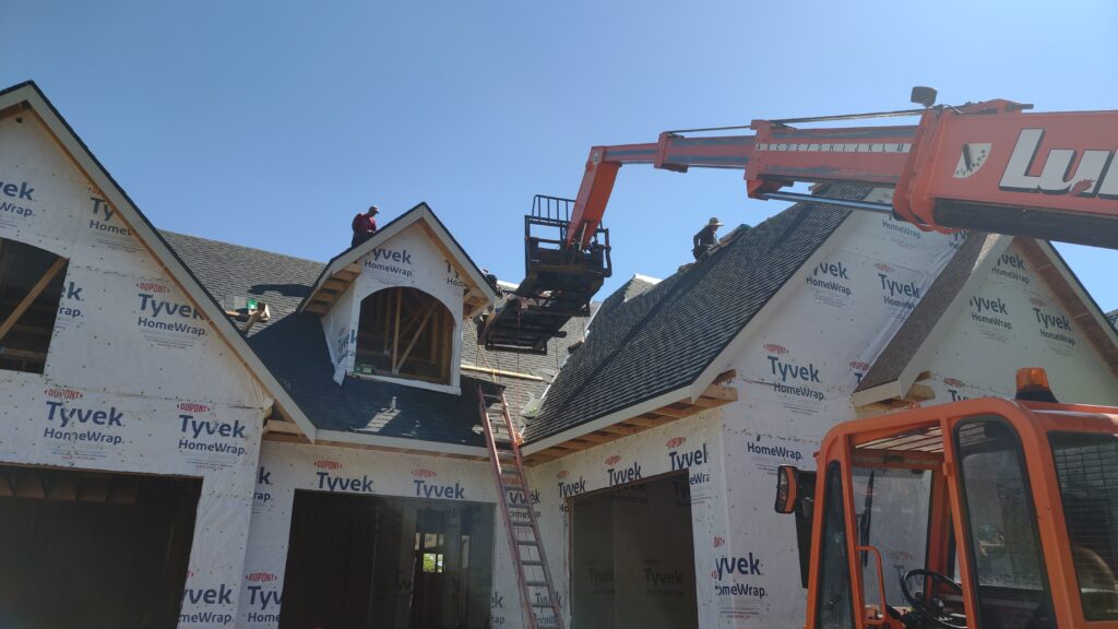 Wolf Roofing crew installing a new construction roof from a lift