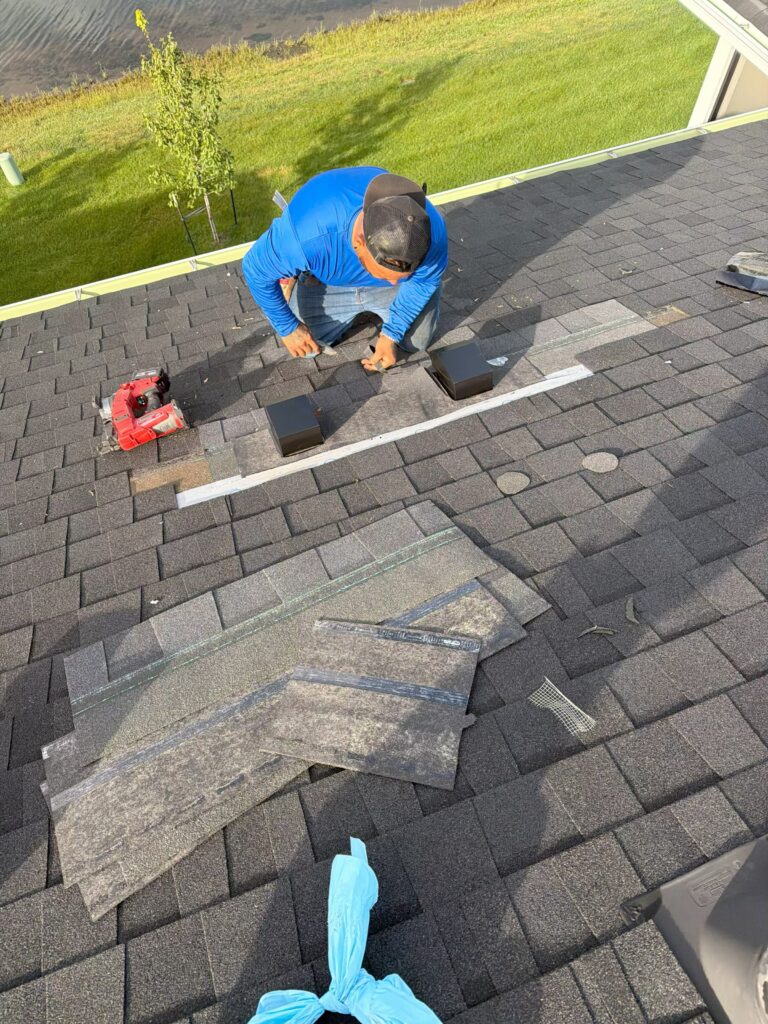 Wolf Roofing crew member replacing storm-damaged shingles