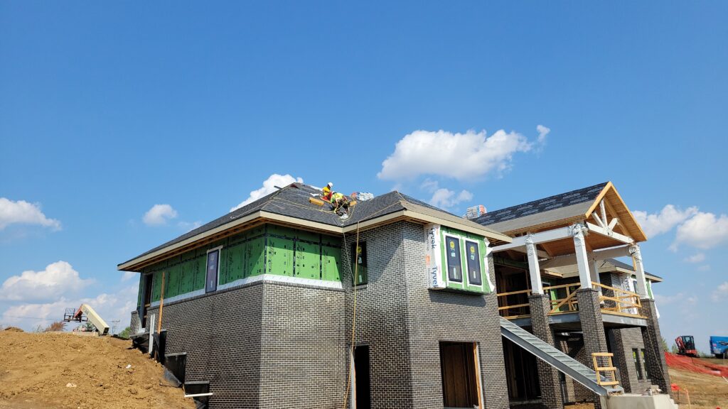 Wolf Roofing crew wearing safety harnesses on a new construction roof in Iowa
