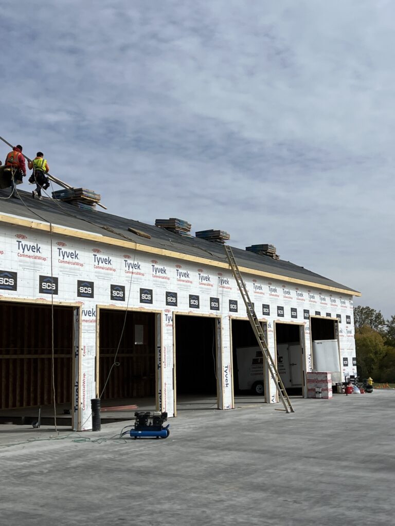 Wolf Roofing crew shingling a new commercial building in Iowa