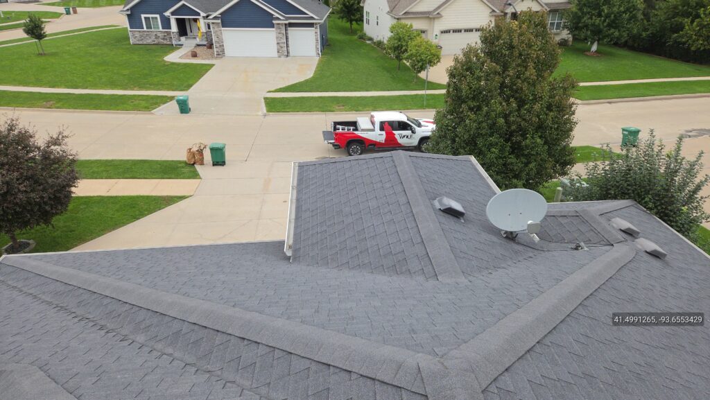 View from a roof of the Wolf Roofing truck parked in the driveway at a repair job